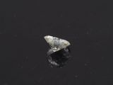 a diamond on a black surface with a reflection in the water