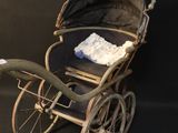 an old fashioned baby stroller with a blanket on top of it