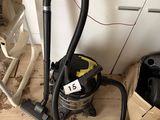 un aspirateur posé sur le sol à côté d'une poubelle
