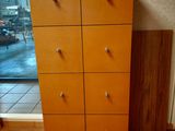 a tall wooden cabinet with six drawers in front of a window