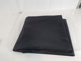 un gros plan d'un tissu noir plié posé sur une surface blanche