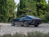 an image of a black sports car parked on a cobblestone road