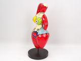 figurine of a man in a red suit sitting on top of a red apple