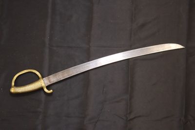 un très long couteau posé sur un tissu noir