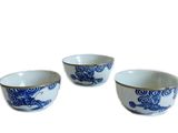 trois bols bleus et blancs ornés de motifs de dragons, posés sur un fond blanc