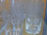 bottles and glasses on display in a glass case on a table