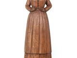 une vieille statue en bois représentant une femme en robe longue