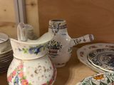 many plates and cups on a table with a teapot
