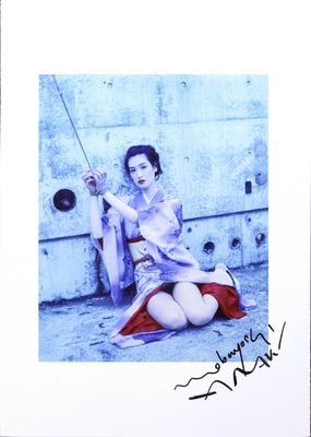 photograph of a woman sitting on the ground with a radio in her hand