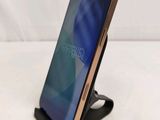 a close up of a cell phone on a stand on a white surface