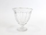 un vase en verre transparent posé sur une surface blanche