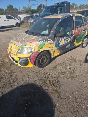 a car that has been painted with graffiti on the side of the road