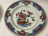 two plates that have flowers on them on a table