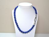 a close up of a necklace on a mannequin with blue beads