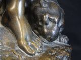 bronze statue of a boy with a dog on a rock