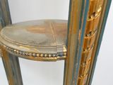 une étagère dorée et bleue sur laquelle est posé un miroir