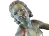 a bronze statue of a woman holding a tennis racquet