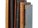 several old books stacked on top of each other on a white surface