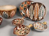 many different types of pottery on display on the table