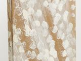 an old book with white paint on it sitting on a white surface