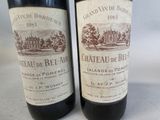 two bottles of red wine sitting next to each other on a table