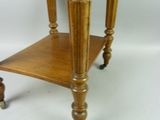 a small wooden table with a glass top on wheels