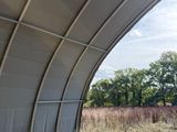 a train that is going under a bridge in a field
