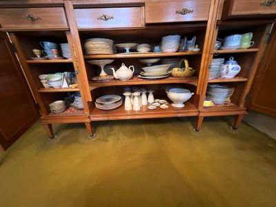 une armoire en bois sur laquelle sont posés de nombreux assiettes et bols