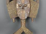 un gros plan d'un masque en bois sur fond gris