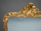 an antique mirror with a gold frame on a grey background
