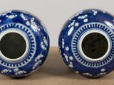 two blue vases sitting on a table with a brown surface