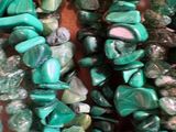 a close up of a bunch of green beads on a table
