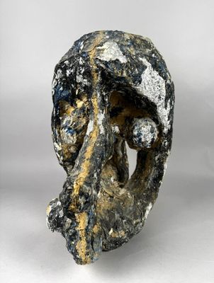 un gros plan d'une sculpture représentant un visage sur une surface blanche