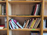a book shelf with many books on it in a room