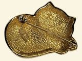 an image of a gold brooch with a pin in the shape of a fish