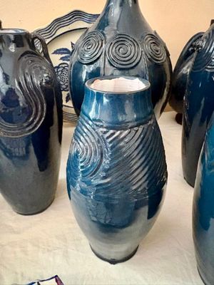 quatre vases bleus posés sur une table recouverte d'une nappe blanche