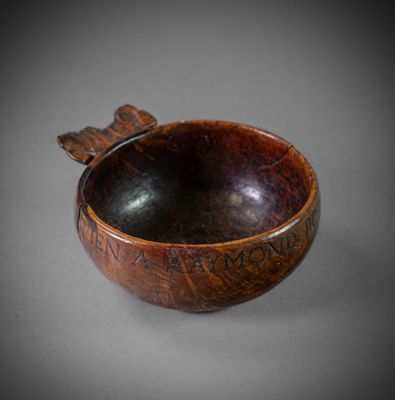 wooden bowl with writing on it sitting on a gray surface