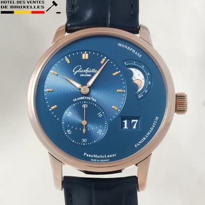 a close up of a wrist watch with a blue dial