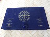 an old blue book with a gold cross on it sitting on a table