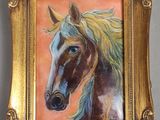 un tableau représentant un cheval, dans un cadre doré, accroché au mur