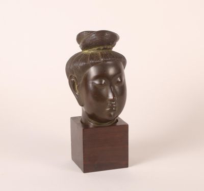 sculpture d'une tête de femme sur une base en bois