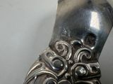 a silver spoon with a design on it sitting on a table