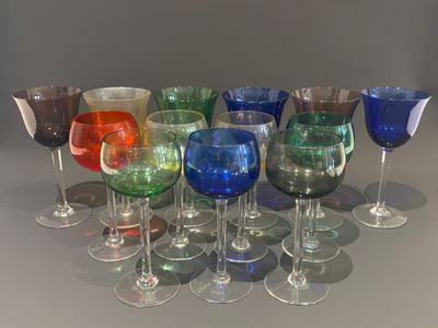 many different colored wine glasses lined up on a table