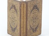 an old book that is open on a white surface