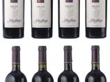 six bottles of red wine are lined up on a white surface