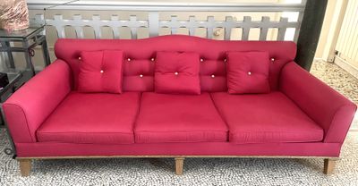un canapé rouge avec des coussins dans un salon