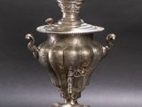 an image of a silver vase with a lid sitting on a tray