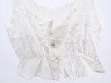 white top with ruffles on a hanger against a white background