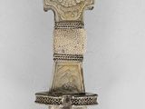 a silver object with a cross on top of it