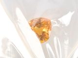 a yellow diamond in a clear bag on a table